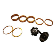 Gold headset spacer set laid out with its star nut and top cap