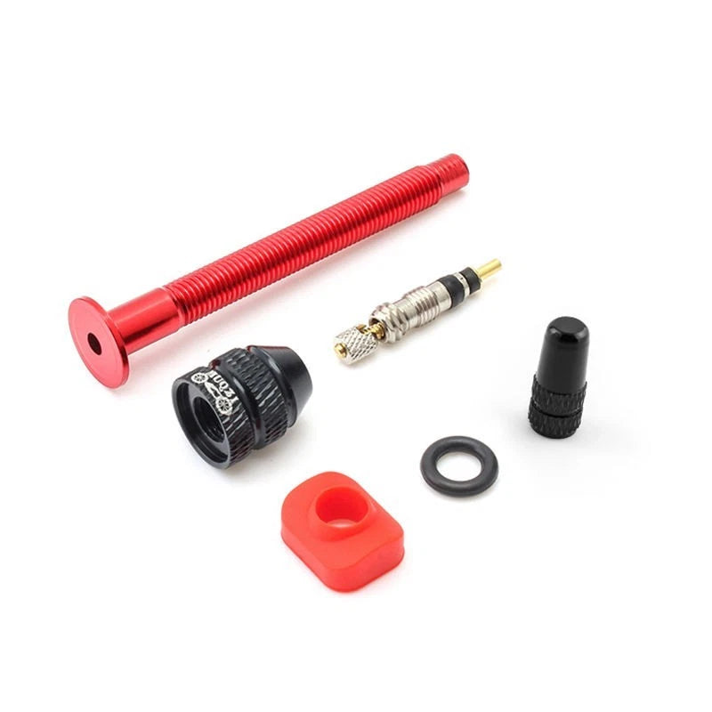 Red tubeless valve stripped down to show the removable core, cap and washer