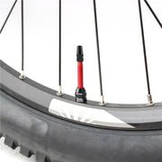 Red tubeless valves fitted to a mountain bike rim