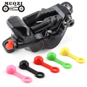 Coloured silicone bleed nipple covers beside a hydraulic disc brake caliper