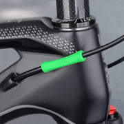 Green silicone protector fitted where a cable runs along a carbon frame