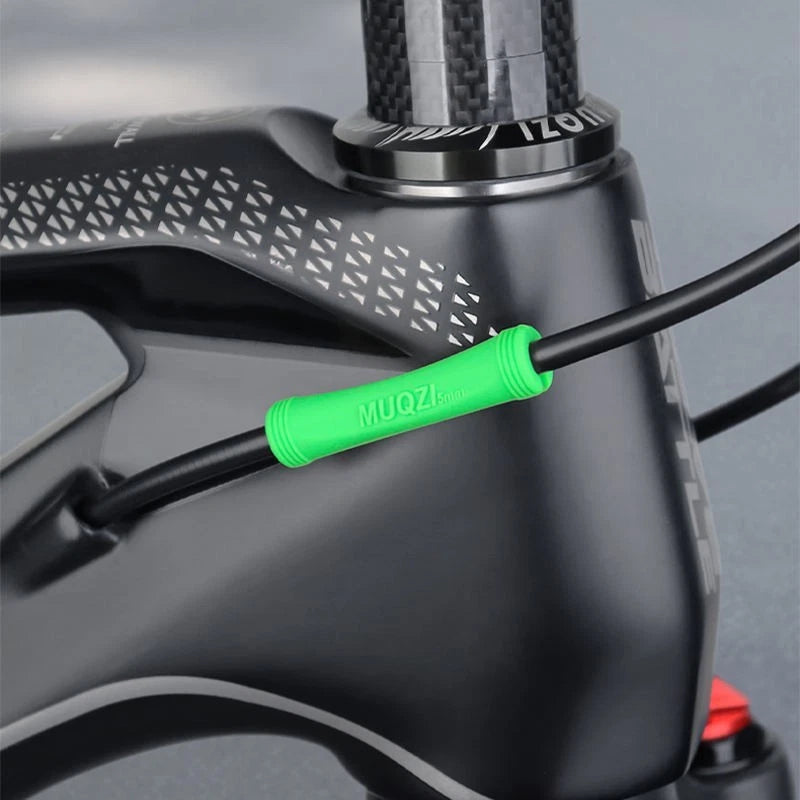 Green silicone protector fitted where a cable runs along a carbon frame